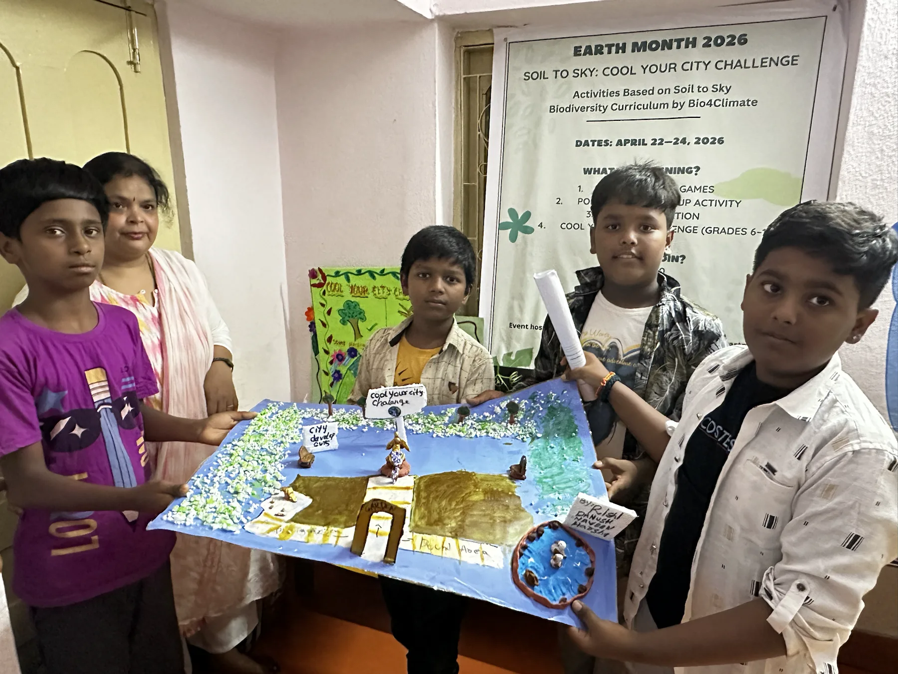 Team three presents a clay model of a garden with a pond and nature-based cooling features.