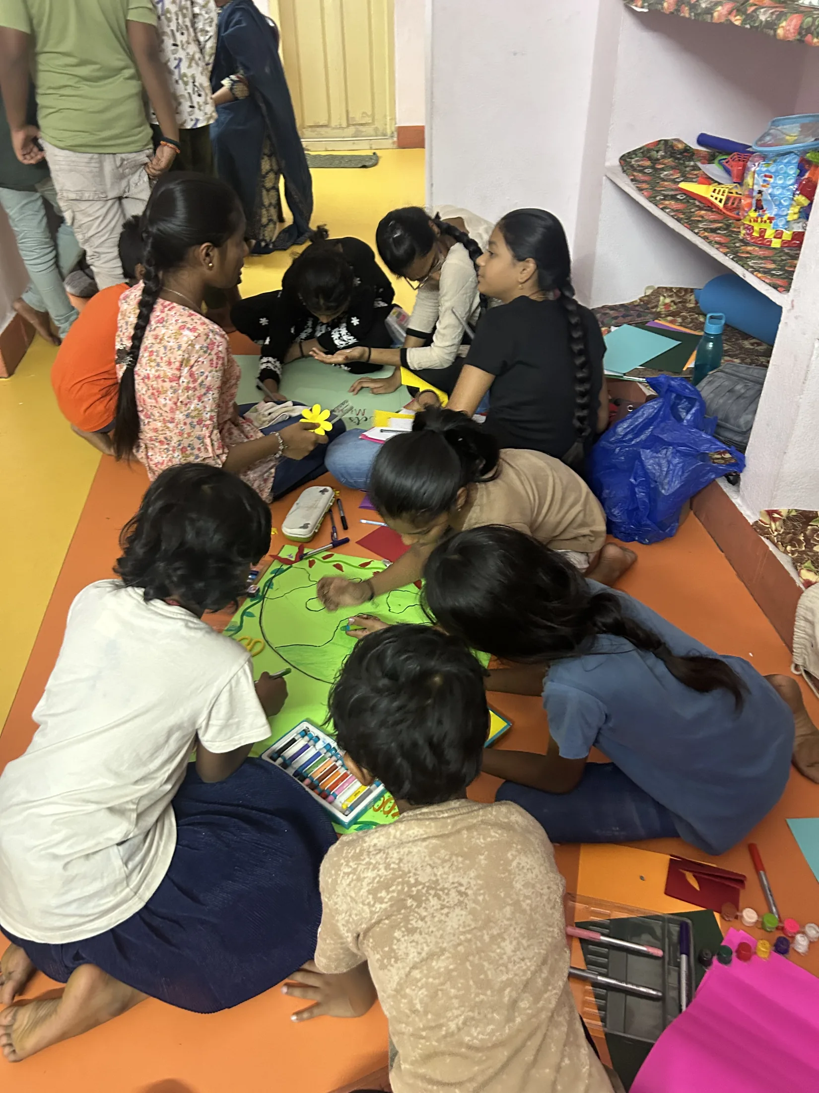 A larger group of children continue preparing posters and flyers for the concluding presentation day.