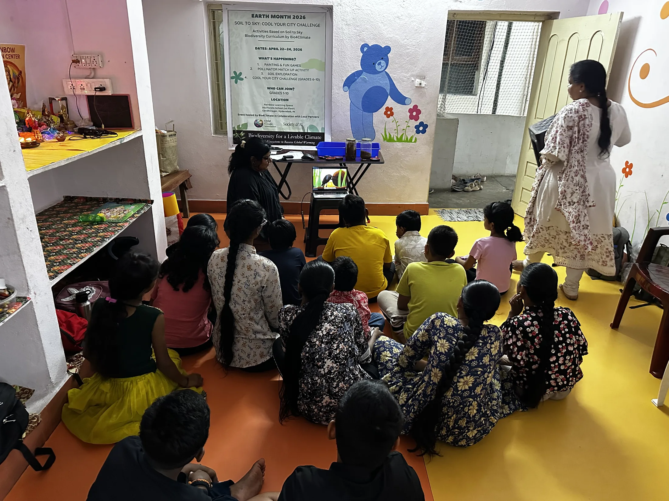 Children listen as Poulomi Chakravarty facilitates the soil and biodiversity session.